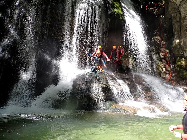 Une femme qui prend la pose accoudée à un roché devant une cascade du Furon, canyon dans le Vercors à 10 minutes de Grenoble